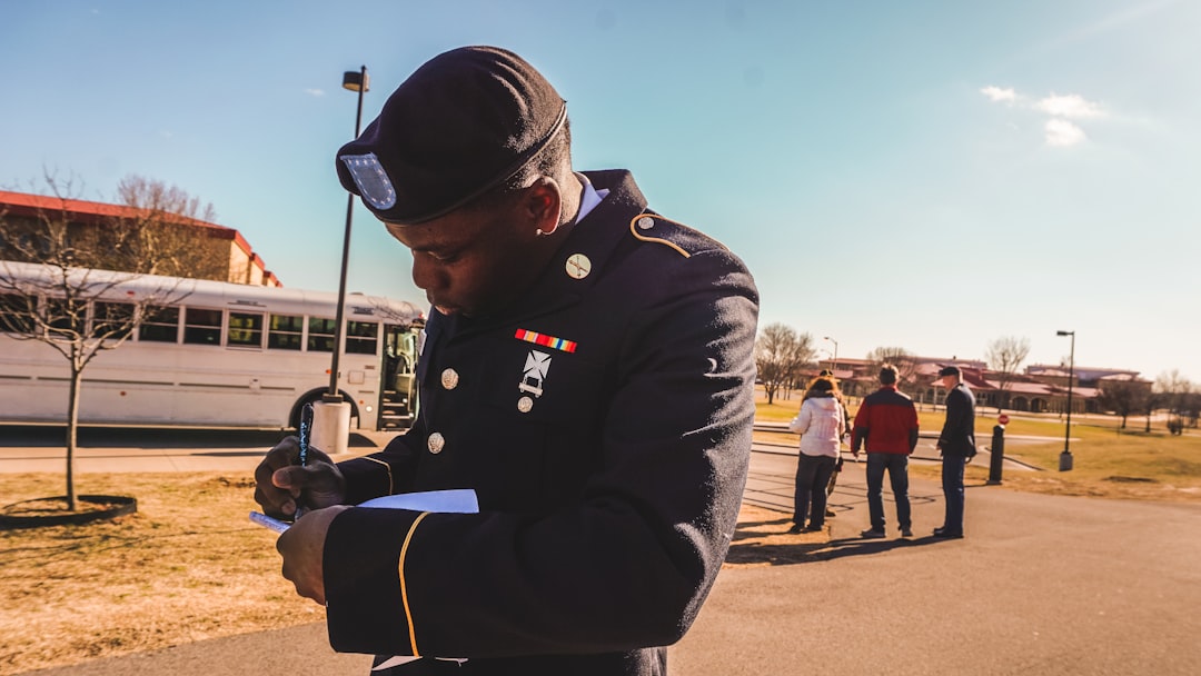 Military soldier in uniform writing on a notepad outdoors